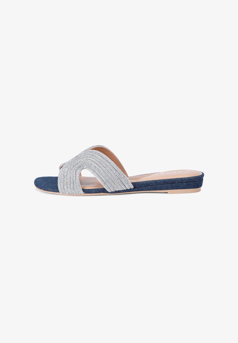 Flat slide sandal with a denim base and silver metallic band, featuring a curved design and textured accents for added detail.