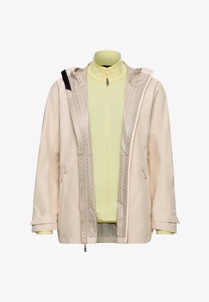 Beige waterdichte jas met een patroon aan de binnenkant, gedragen over een lichtgele fleece jas met rits en opstaande kraag.