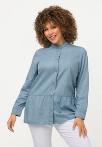 Helles blaues Hemd mit Knopfverschluss, rundem Kragen, langen Ärmeln und gerafftem Bund; aus Denimstoff mit glatter Textur.