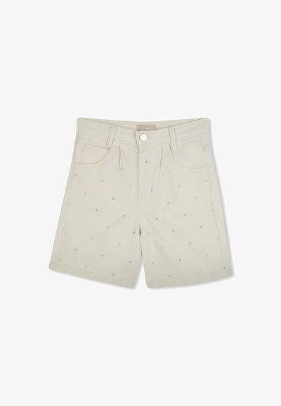 Shorts beiges en coton avec une surface texturée, portant de petits points métalliques régulièrement espacés sur le tissu. Comprend des poches avant et une ceinture.