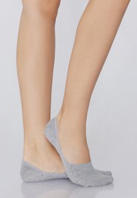 Le calze invisibili grigie presentano una morbida trama a maglia con una silhouette a taglio basso, progettate per rimanere nascoste all'interno delle scarpe.