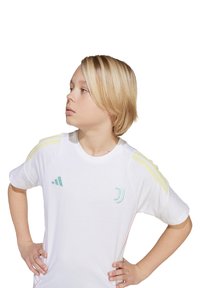 Juventus-shirt in het wit, met gele strepen op de schouders en een turquoise logo. Crew neck ontwerp, lichtgewicht stof, casual pasvorm.