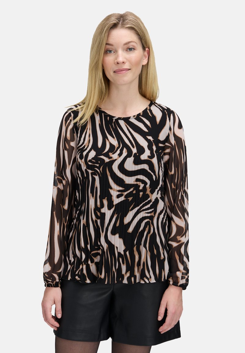 Chemisier à manches longues en tissu noir transparent avec un motif abstrait beige et marron, doté d'un col rond et de poignets froncés.