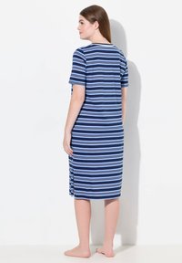 Abito a righe blu navy con maniche corte, lunghezza al ginocchio e spacchi laterali. Realizzato in un tessuto morbido, presenta righe orizzontali blu e blu chiaro.