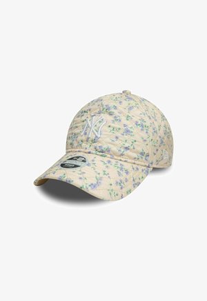 Casquette beige matelassée avec un motif floral intégral en violet et vert. Équipée d'un logo brodé blanc et d'une visière incurvée.