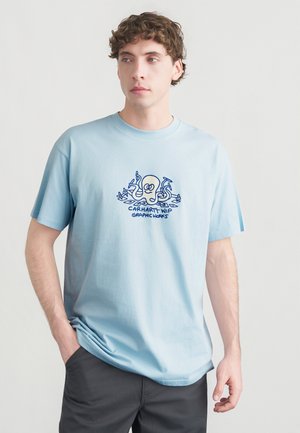 T-shirt en coton bleu clair à manches courtes, avec un graphique bleu d'une pieuvre et le texte "Carhartt WIP Graphic Works" en dessous.