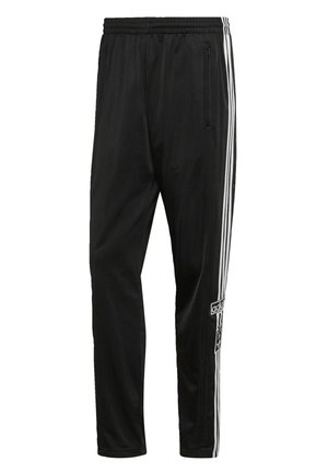 Czarne spodnie sportowe z elastycznym paskiem, zamykaną na zamek kieszenią boczną, białymi paskami po bokach oraz naszywką z logo Adidas na prawej nodze.