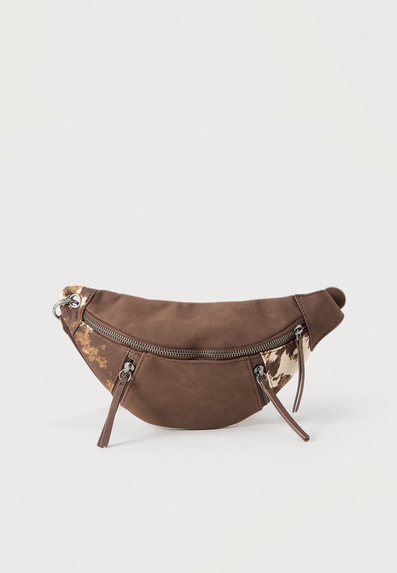 Sac banane en daim marron et toile avec accents à motif animalier, trois poches zippées et sangle réglable sur un fond uni.