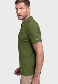 Olivgrünes Poloshirt mit Kragen, seitlichen Schlitzen und einer Brusttasche. Mit dem weißen "Schöffel"-Logo auf dem Ärmel.