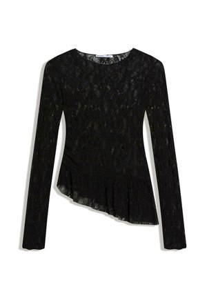 Blouse noire à manches longues en dentelle avec encolure ronde et ourlet asymétrique à volants sur fond blanc.