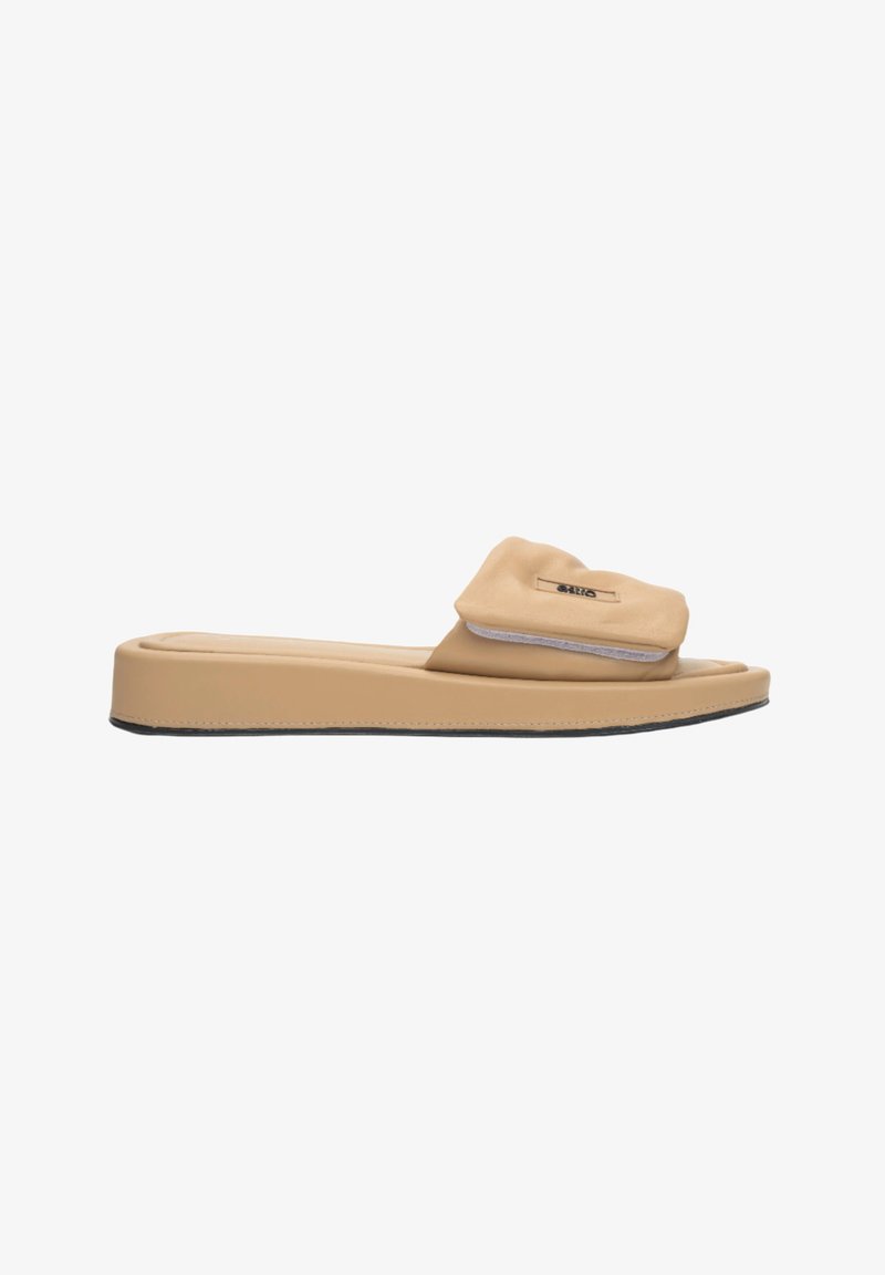 Beige schuifsandalen van zacht materiaal met een geplooid bovenwerk. Platte zool met minimale antislip en een subtiele logodetail op de band.
