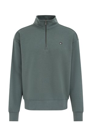 Tamnozeleni pulover s polu-rajfešlusom na ovratniku, rebrastim rubom i manžetama, te malim izvezenim logotipom na prsima. Mekana tekstura materijala.