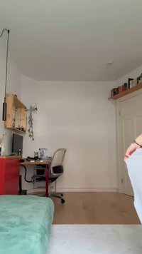 Light gray fabric hanging, showing smooth texture. Background features a desk with a red drawer unit and an office chair under a shelf.