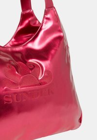 Borsa a tote sintetica rosa lucida con parte superiore curva, logo embossato e dettagli floreali. Texture liscia e manici regolabili.