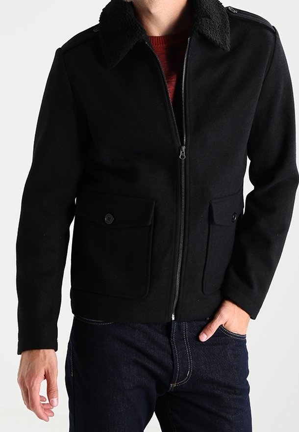 Svart zip-up jacka med en mjuk, texturerad krage, två framfickor och en figursydd design. Tillverkad av varmt, hållbart tyg.