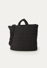 Black quilted tote bag with a textured pattern, featuring short handles and an adjustable shoulder strap. Smooth fabric with soft finish.