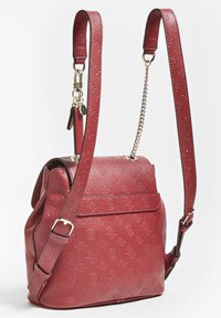 Sac à dos en cuir rouge avec un motif floral en relief, sangles réglables, détail en chaîne dorée et poche externe à l'avant.