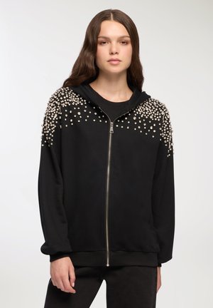 Felpa nera con zip e design texturizzato; presenta decorazioni sulle spalle. Realizzata in tessuto morbido, con cappuccio.