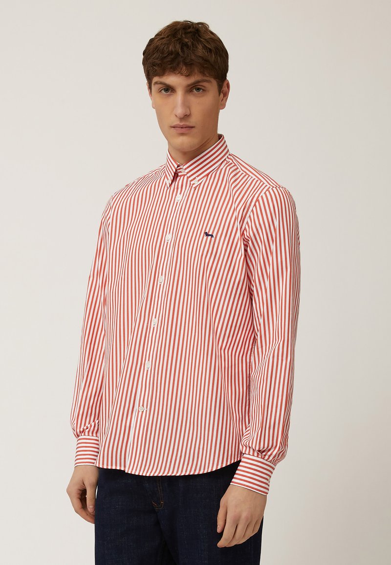 Camisa de botones a rayas rojas y blancas con mangas largas, que presenta un cuello extendido y un pequeño logo azul en el pecho.