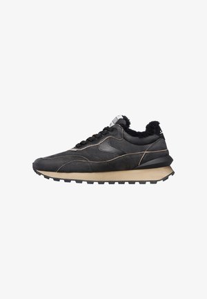 Sneaker nera con tomaia in suede testurizzato, intersuola in schiuma beige a contrasto e suola in gomma; presenta lacci e un branding minimale.
