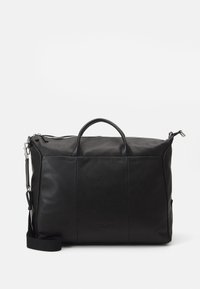 Black leather duffel bag with two top handles, a detachable shoulder strap, and zipper closure. Features flat seams and subtle branding.