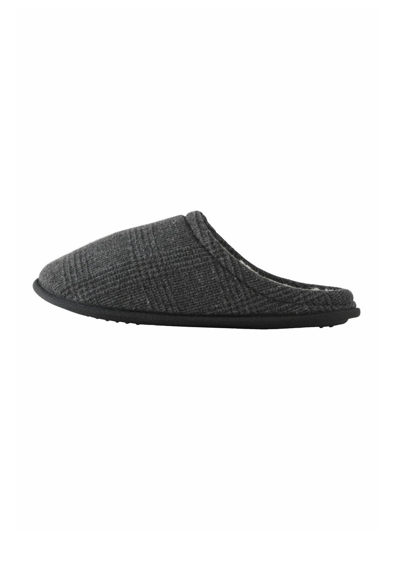 Zapatilla de casa de cuadros grises con parte superior suave, punta redondeada y suela de goma negra. Diseño ligero, ideal para la comodidad en casa.