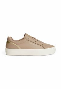 Baskets en cuir synthétique beige avec une semelle blanche, à laçage plat et un subtil accent doré au niveau du talon. Présente un détail de logo près des lacets.