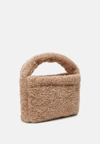 Sac à main beige texturé en matériau doux. Il dispose d'une poignée ronde et d'une forme rectangulaire avec une surface douce et moelleuse.