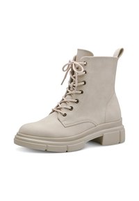 Botines beige con cordones, con un acabado de ante suave, que presentan puntera redonda, tacón grueso y ojales de metal. Lengüeta en la parte trasera para facilitar el calzado.