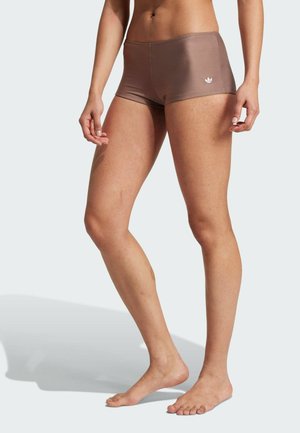 Shorts de sport marron en tissu lisse et extensible avec une taille élastique. Dispose d'un logo blanc sur la hanche gauche.