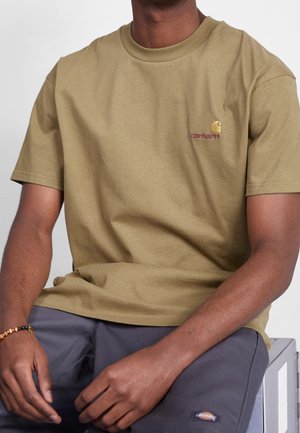 Olivgrünes Baumwoll-T-Shirt mit kurzen Ärmeln, geripptem Rundhalsausschnitt und aufgesticktem "Carhartt"-Logo in Kastanienbraun auf der linken Brust.