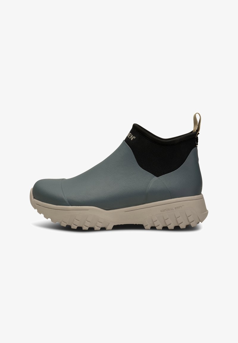 Chaussure d'extérieur de hauteur moyenne avec tige en cuir bleu, col extensible noir, semelle épaisse crantée beige et languette à l’arrière.