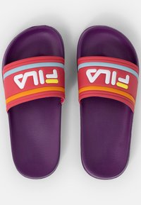Violet slidesit langenäm, qolla tükkiv sets, punased ja mitmevärvilised rihmad, millel on valge "FILA" bränding. Lametootud, avatud varvased disain.