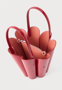 Κόκκινη γυαλιστερή τσάντα ώμου με άκρες σε σχήμα πέταλου, διπλές λαβές και ροζ επένδυση. Διαθέτει μια μικρή εσωτερική θήκη με φερμουάρ.