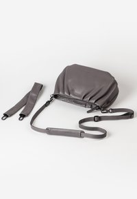 Gray leather bag with a gathered design, zip closure, and detachable shoulder strap. Features smooth texture and minimalistic style.