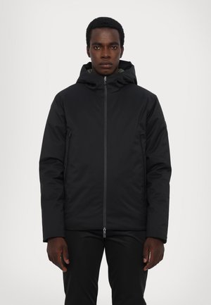 Veste noire isolée avec capuche, dotée d'une fermeture éclair à l'avant et de poches latérales, texture lisse, design simple et sans motifs visibles.