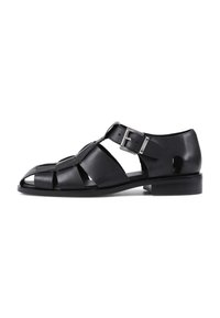 Sandales en cuir noir avec un design découpé, système de fermeture à boucle et talon bas. Caractéristiques d'une semelle plate et d'un bout ouvert pour la respirabilité.