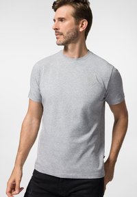 Szary, krótki t-shirt z miękkiego, lekkiego materiału, z okrągłym dekoltem i subtelnym wytłoczonym logo na klatce piersiowej.