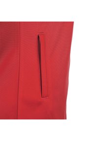 Tessuto rosso con una consistenza liscia, caratterizzato da una tasca verticale discreta con apertura superiore. Cuciture pulite e design minimalista.