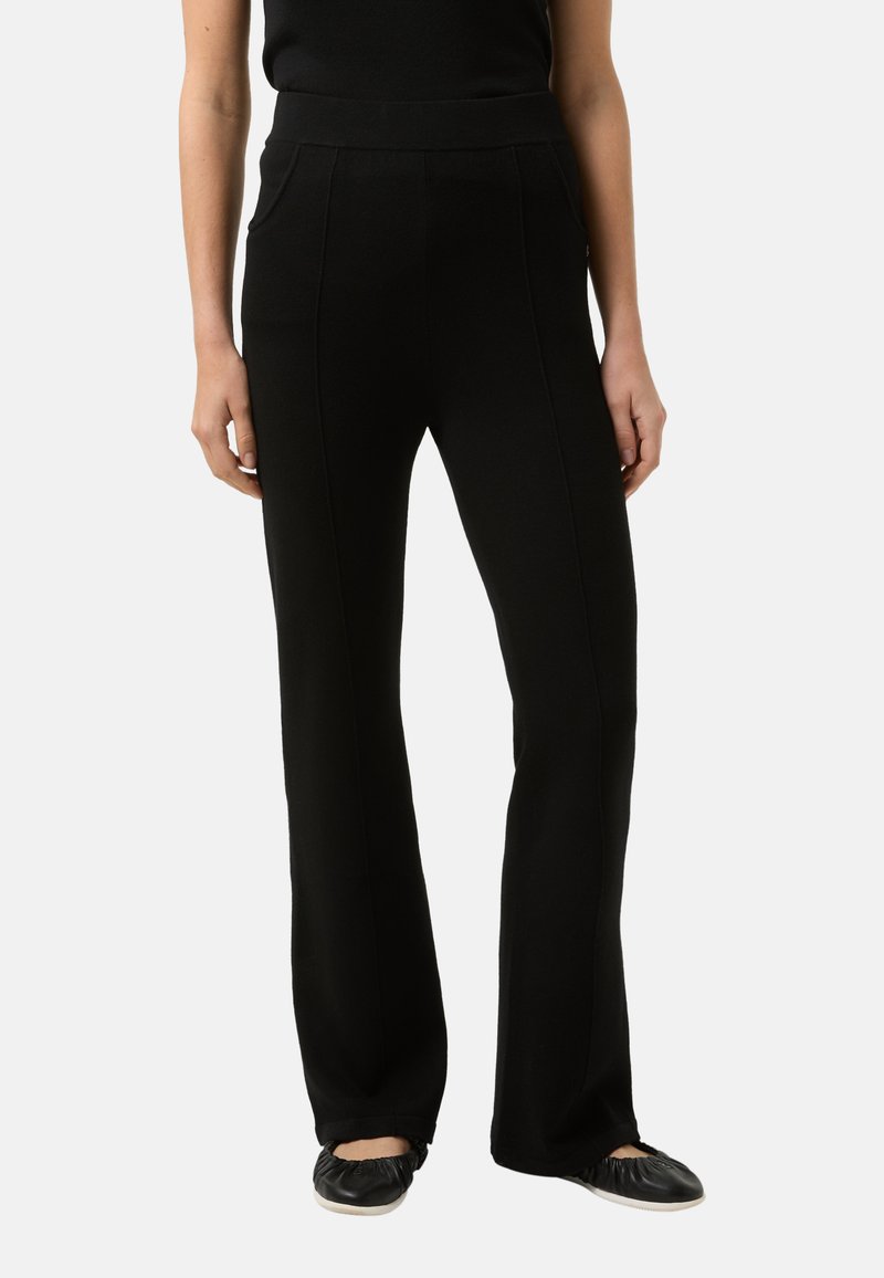 Schwarze, ausgestellte Hose mit glatter Textur, hohem Bund und Vorder Taschen. Verfügt über vertikale Nähte für ein maßgeschneidertes Aussehen.