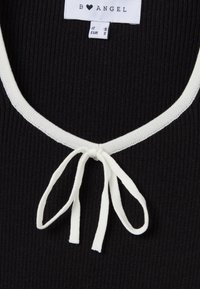 Top nero a costine con scollatura a maglia bianca e chiusura anteriore con fiocco. Le etichette interne indicano marca e taglia.