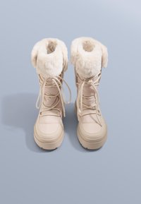 Beige winterlaarzen met imitatiebontbies, vetersluiting, gewatteerde schacht en dikke rubberen zool voor verbeterde grip en isolatie.