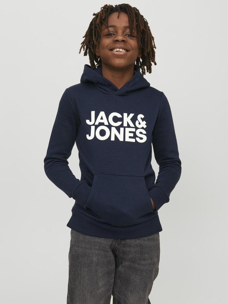 Temno modra kapuca z belim napisom "JACK & JONES", s sprednjim žepom in kapuco, v kombinaciji s temno sivo džins hlačami.