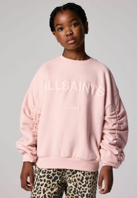 Felpa rosa con polsini a coste, testo audace "ALLSAINTS" e "LONDON," con maniche arricciate. Abbinata a pantaloni con stampa leopardata.