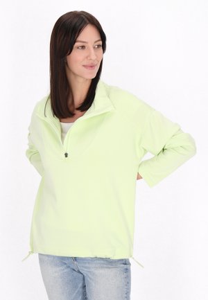 Lys grøn pullover med halv lynlås krave, lange ærmer og justerbare sidekanter. Glat tekstur og afslappet pasform med et enkelt design.