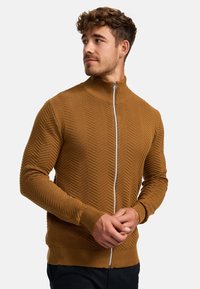 Brun zip-up sweatshirt med ett strukturerat herringbone-mönster, ribbade ärmslut och krage. Lätt stickad tygkvalitet, slim fit-design.