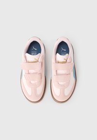 Ljusrosa sneakers med kardborreband, blå accenter och guld branding. Slät och texturerad paneldesign med en brun gummisula.
