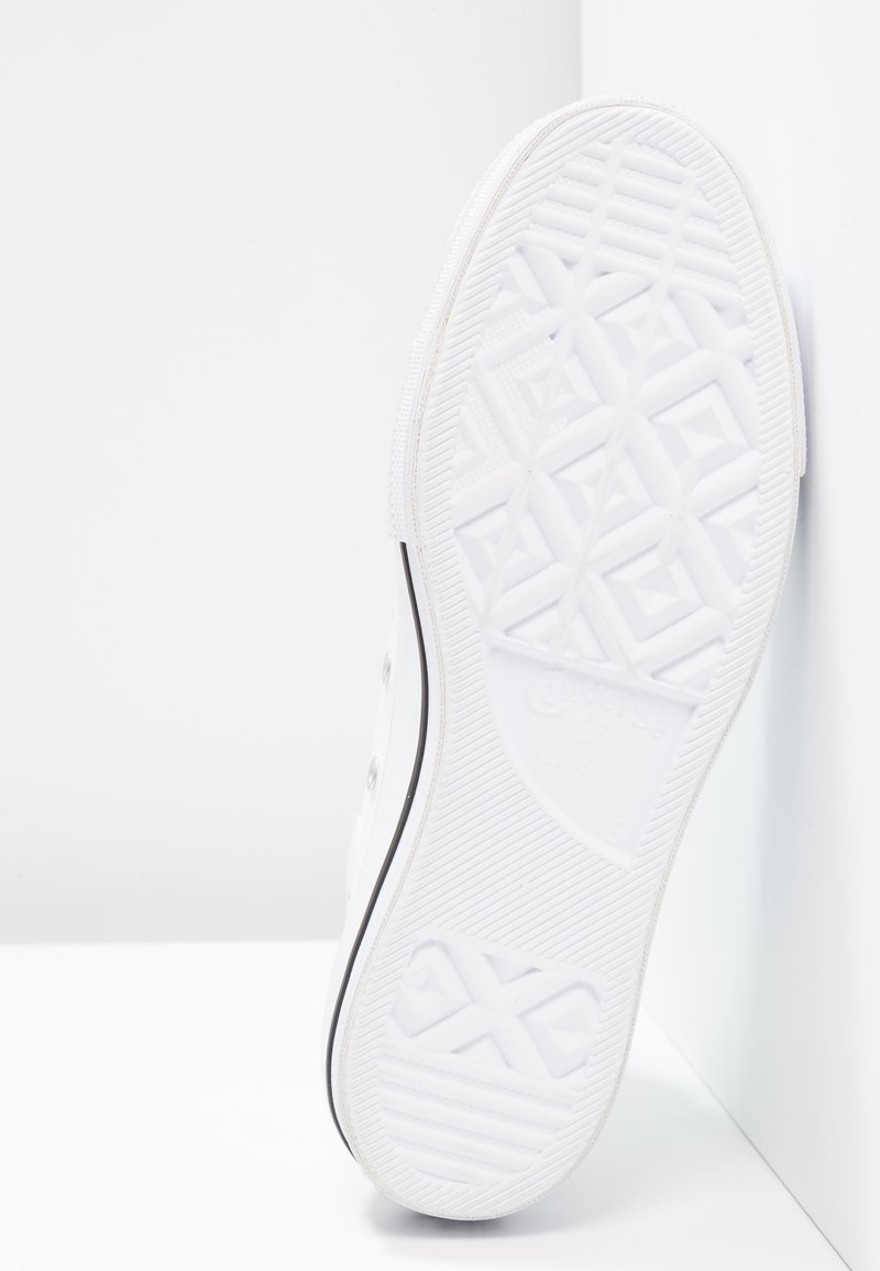 Suela de zapatilla de goma blanca con un patrón de relieve geométrico, con borde negro alrededor del perímetro. Sin marcas visibles ni detalles adicionales.