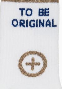 Calzini bianchi con testo marrone e blu che recita "TO BE ORIGINAL" e un disegno di cerchio marrone con un segno più vicino alla caviglia. Tessuto a maglia morbido.