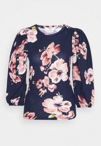 Navy top with puff sleeves, featuring a floral pattern in pink and white. Made from soft fabric with a round neckline and relaxed fit.